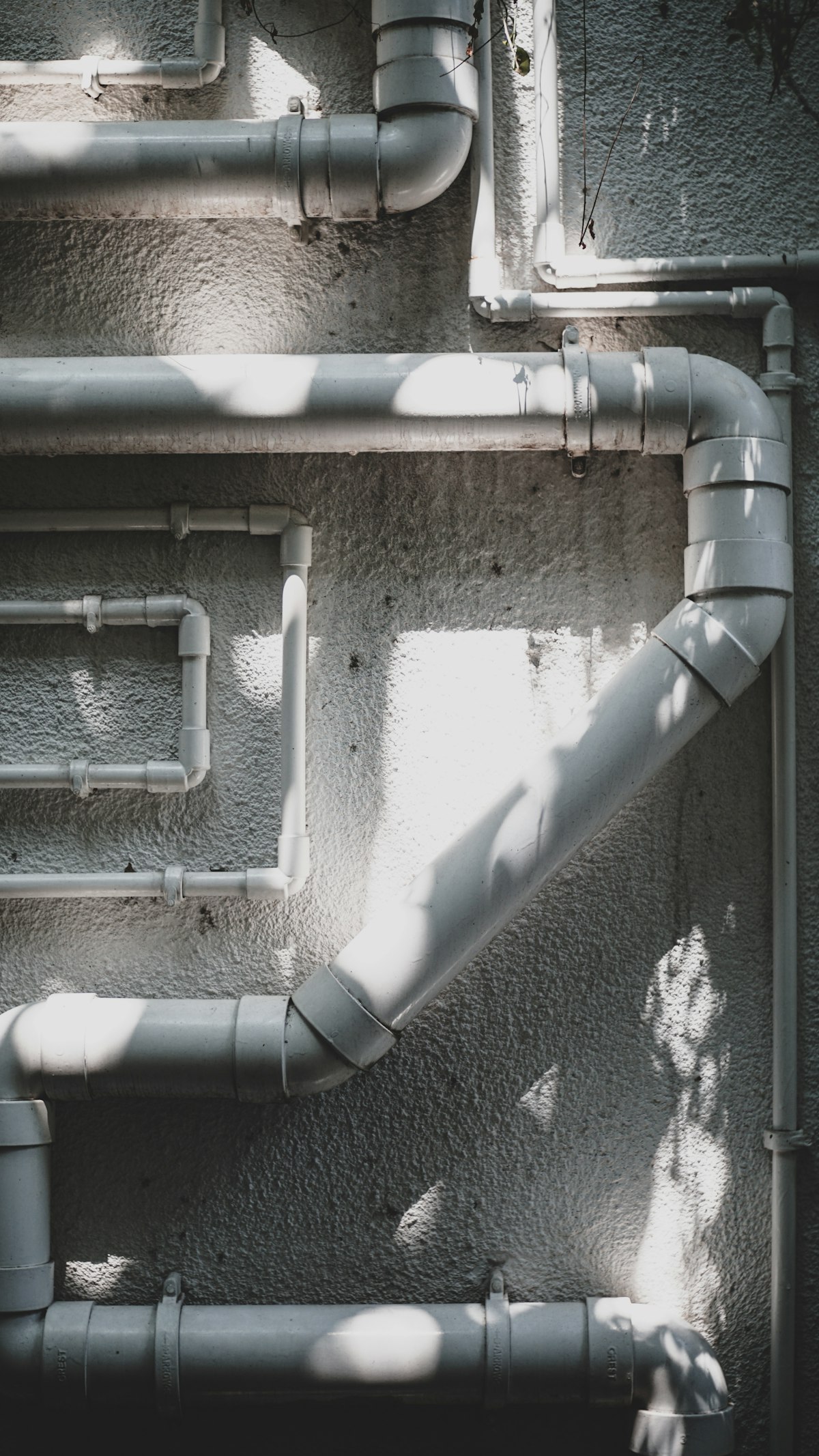 Coudes et raccords de tuyauterie sur une façade